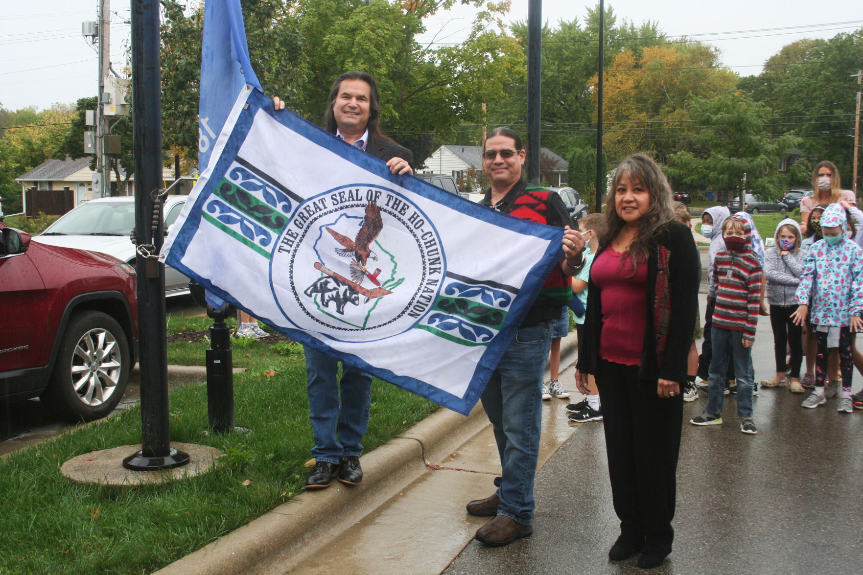 Brown, Warner, and Tracy hold the flag